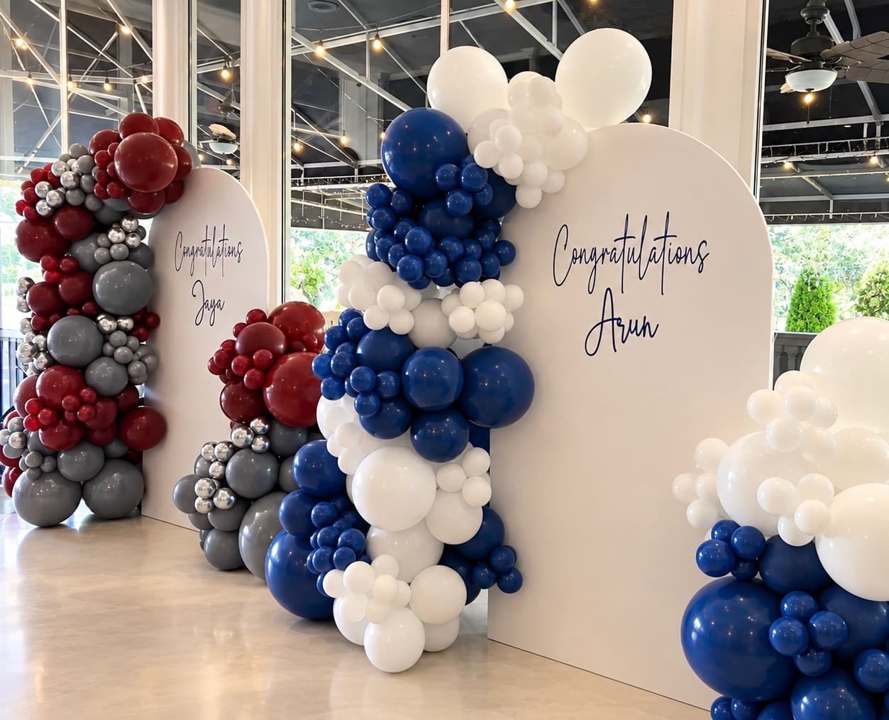 Paired graduation backdrops with navy, white, burgundy, and gray balloons